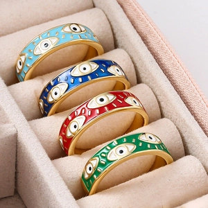 Macro shot of colorful enamel evil eye rings in light blue, dark blue, red, and green