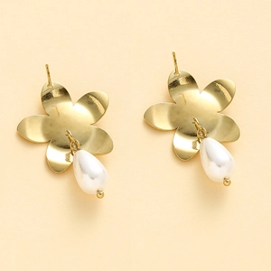 Macro shot of gold floral earrings with elegant white teardrop pearl pendants