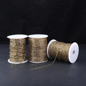 Detail of 18k gold plated stainless steel paperclip chain on white spools for DIY jewelry