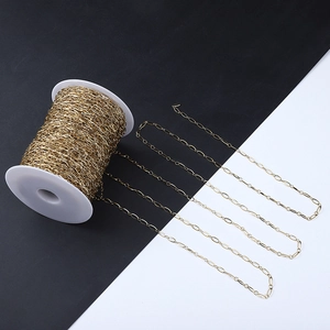 Close-up of bulk 18k gold plated stainless steel paperclip chain on white plastic spool