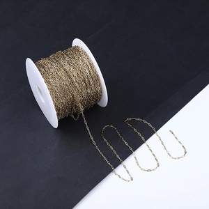 Detail of 18k gold plated stainless steel paperclip chain on a white spool
