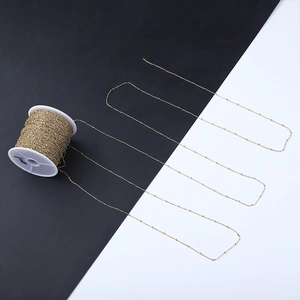 Detailed view of 18k gold plated stainless steel bead chain on a spool for DIY jewelry