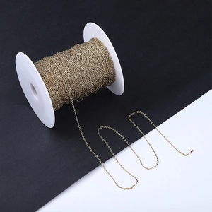 Macro shot of 18k gold plated stainless steel paperclip link chain on a white spool roll