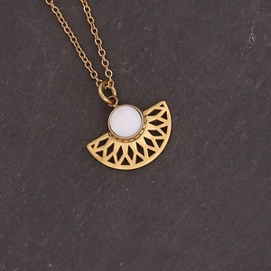 Macro detail of fan-shaped gold titanium steel pendant with white shell inlay