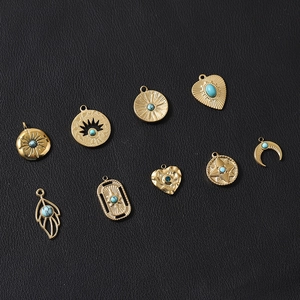 Detailed set of gold moon and heart pendants with turquoise stones on black leather