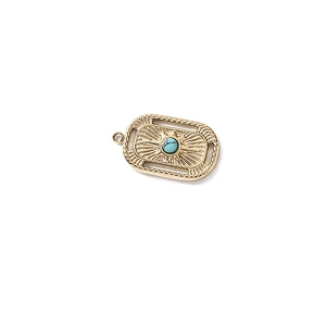 Close-up of gold rectangular moon pendant with turquoise stone and ray texture