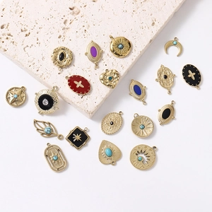 Bohemian gold starburst and geometric enamel pendants displayed on a natural stone surface