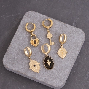 Detail of vintage gold-plated starburst pendants and lock earrings on a stone tray