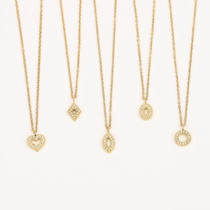 Détail de cinq colliers dorés avec pendentifs géométriques variés et zircons incrustés
