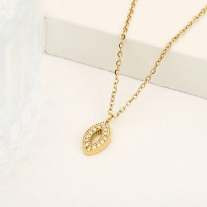 Détail du collier doré avec pendentif marquise ajouré et pavage de cristaux sur chaîne fine
