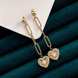 Bohemian gold evil eye paperclip earrings with vintage heart charms on green velvet