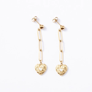 Detailed view of gold paperclip chain earrings with textured heart charms and white enamel