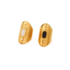 Detail of wide shield rings featuring black and white enamel dots on gold plated metal