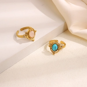 Macro detail of retro gold rings with pink and turquoise stones and woven textures
