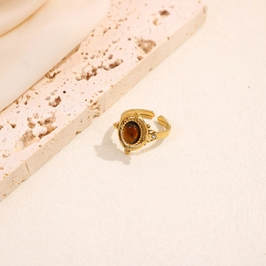 Vintage gold adjustable ring with oval brown tiger eye stone and detailed relief pattern