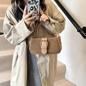 Vintage brown suede underarm bag with large gold buckle in a stylish crossbody style