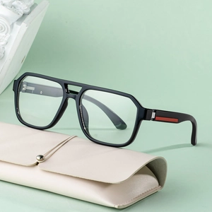 Black square frame sunglasses with red stripe detail and leather case on green background