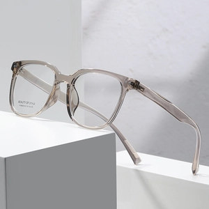 Modern square transparent grey optical glasses frame displayed on minimalist white blocks