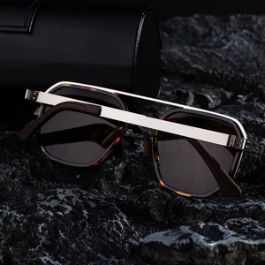Close-up of polarized driving sunglasses with double-bridge frame on volcanic rock