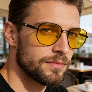 Close-up of square sunglasses with yellow tinted lenses and black metal frames