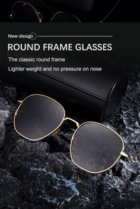 Close-up of retro round gold frame sunglasses with engraved detail on black rock