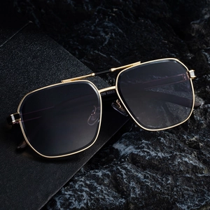 Retro square gold metal sunglasses with gradient lenses on black leather and rock base