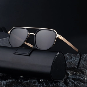 Square double-bridge polarized sunglasses with black and gold frame on dark stone background