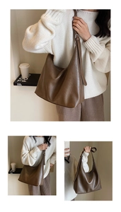 Detail of a brown large capacity hobo bag with litchi texture and silver hardware