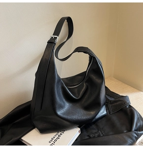 Detail view of large black crescent hobo bag with adjustable wide strap and silver hardware