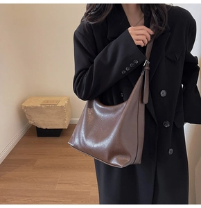 Detail view of deep brown retro leather tote bag featuring a minimalist Hobo style design