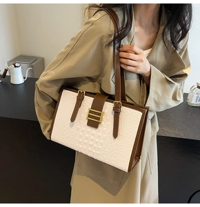 Detail of vintage tote bag with white crocodile pattern and brown leather straps