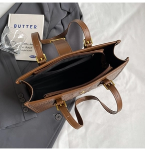 Macro view of interior compartments and brown embossed leather texture of the handbag