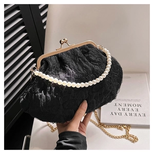 Detail of black lace pleated evening bag with pearl handle and golden chain strap