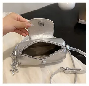 Detail der silbernen Zylindertasche mit Innenfach und magnetischem Klappenverschluss