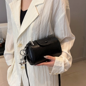 Schwarze Vintage Zylindertasche aus glänzendem Lackleder mit metallischem Kugelanhänger