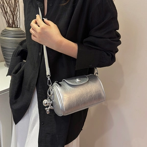 Schicke silberne Zylindertasche mit Metallic-Textur und Ballon-Hunde-Anhänger