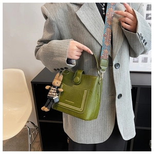 Detail of green vintage bucket bag with contrast stitching and a cute bunny charm