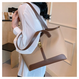 Detail of contrast stitching and gold buckle on two-tone large leather tote bag