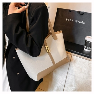Detail of two-tone tote bag featuring lychee grain texture and golden square buckle clasp
