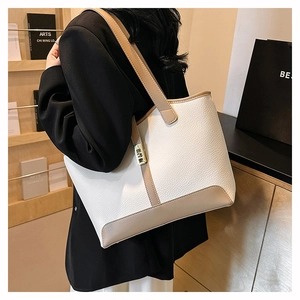 Detail of white and beige tote bag in lychee leather featuring elegant gold square buckle