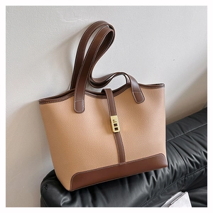 Detail of lychee pattern leather tote bag with gold metal buckle and contrast stitching