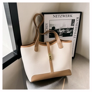 Detail of cream and brown tote bag with pebble leather texture and gold buckle