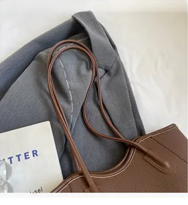 Close-up of brown litchi pattern leather tote bag with durable slim shoulder straps