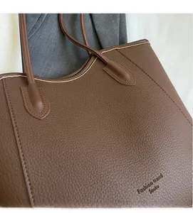 Detail of dark brown lychee grain leather tote bag with wavy edge and spacious interior
