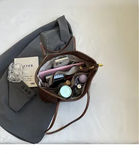 Internal view of brown leather tote showing spacious multi-pocket storage for daily essentials