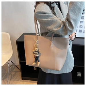 Détail du sac cabas en cuir camel avec surpiqûres blanches et pendentif lapin chic