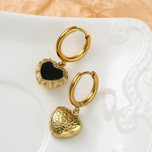 Macro shot of French Baroque heart earrings with black enamel and vine pattern