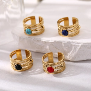 Close-up of four layered titanium steel rings with colorful turquoise and red gemstones