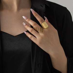 Close-up of stacked gold vintage rings with textured vertical ridges and hollow patterns