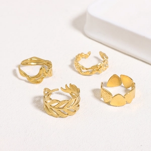 Detail view of four-piece gold irregular open rings featuring feather and lava textures